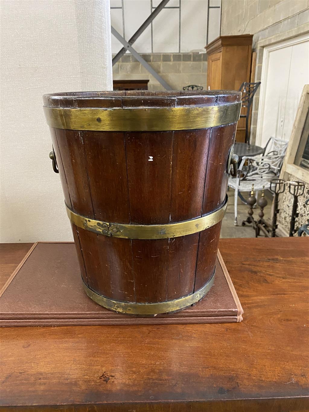 A George III circular brass bound mahogany peat bucket, fitted with two carrying handles, diameter 35.6cm, height 41cm